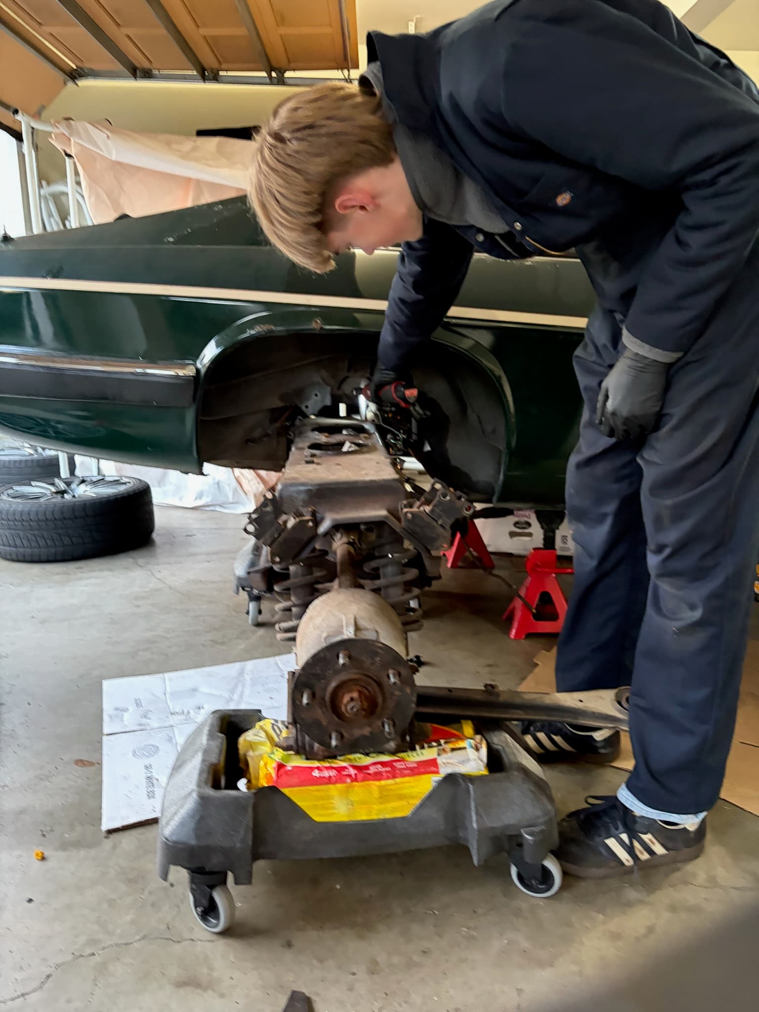 Reinforcements helping to maneuver the subframe back under the car on jack stands